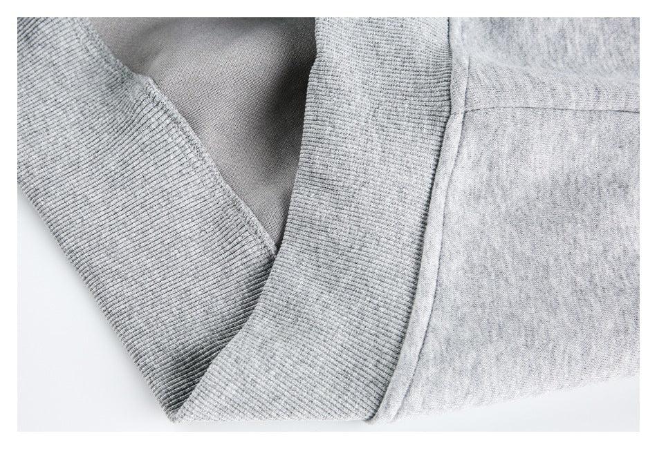 Close-up of the light gray sweatshirt's ribbed trim, seam, and interior fabric.