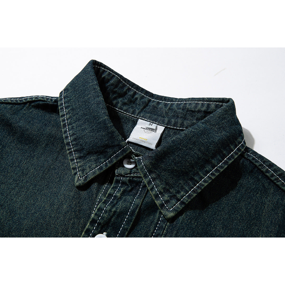 Close-up of a dark blue-green shirt collar with white topstitching and a small neck label.