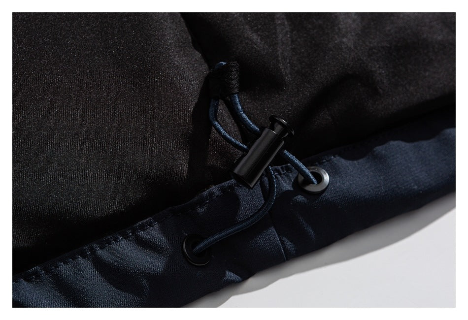 Close-up of a dark garment hem with a cord, eyelets, and adjustable toggle.