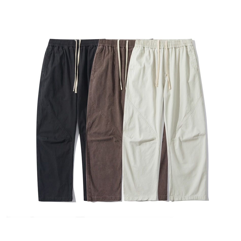 Three pairs of loose straight-leg pants with elastic drawstring waists in black, brown, and ivory.