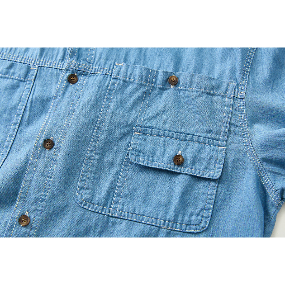 Close-up of the light blue shirt's button placket and chest pockets, including one buttoned flap pocket.