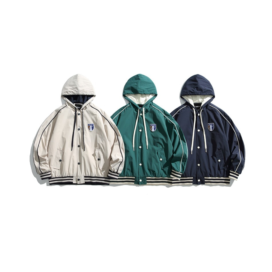 Three hooded jackets shown side by side in cream, teal, and navy, each with contrast piping and striped trim.