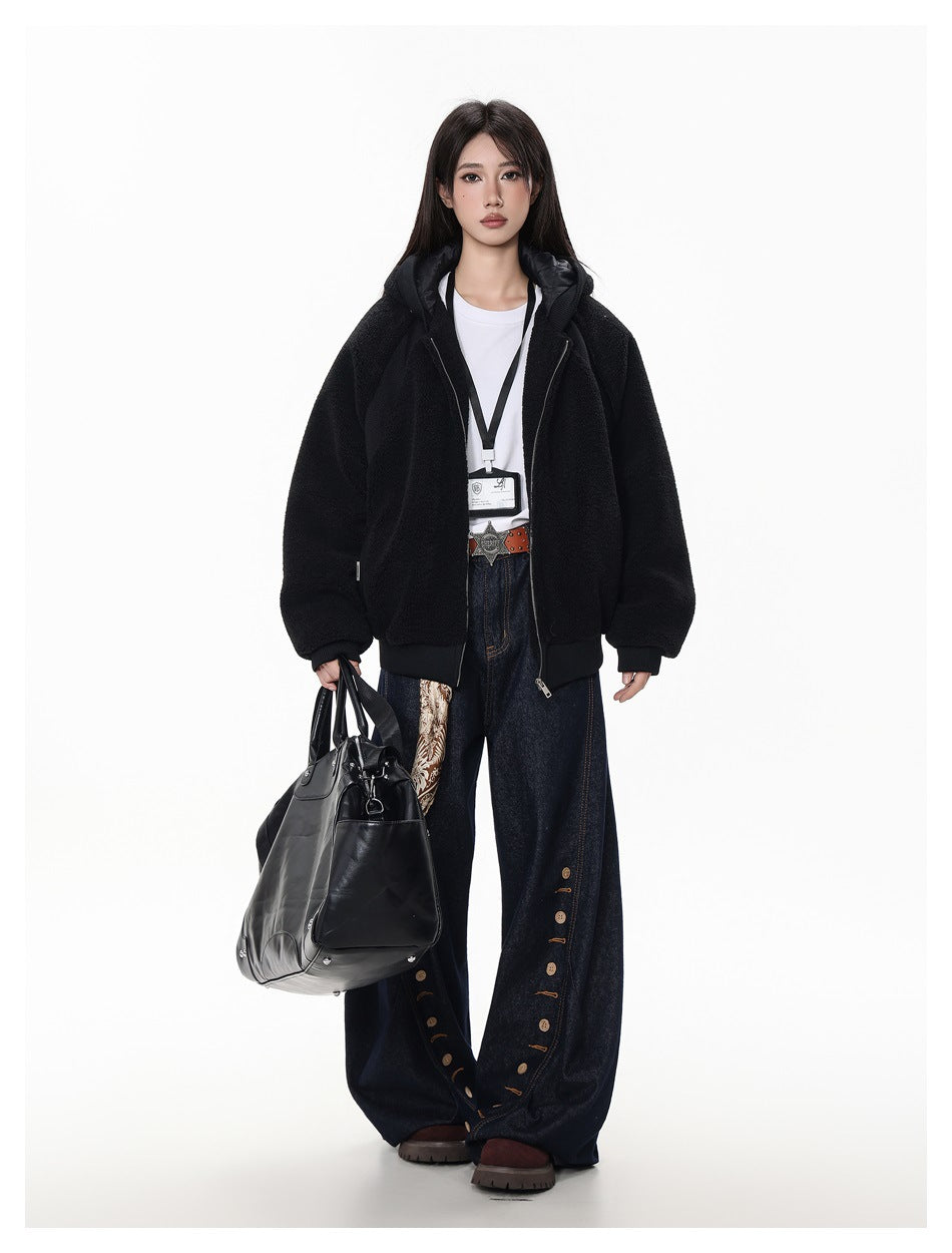 Full-length view of a model in a black hooded fleece-style zip jacket, white tee, wide-leg jeans and a black tote bag