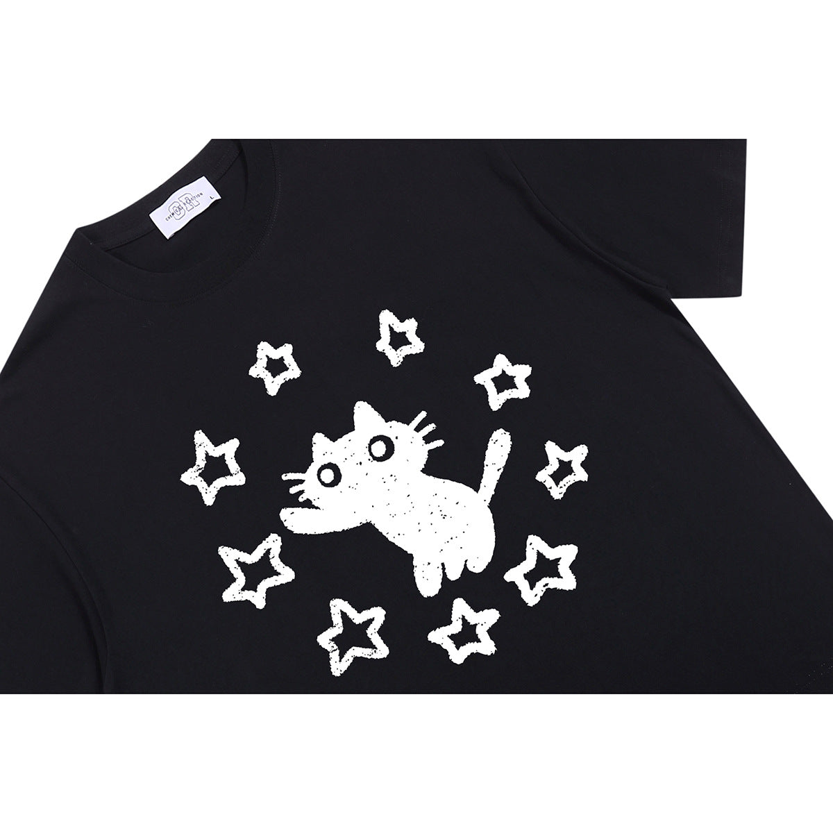 Close-up of a black T-shirt with a white cat and star graphic on the front.