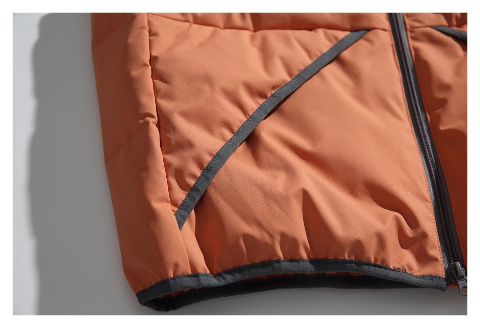 Close-up of a rust-orange jacket with dark piping along the hem and a black front zipper.