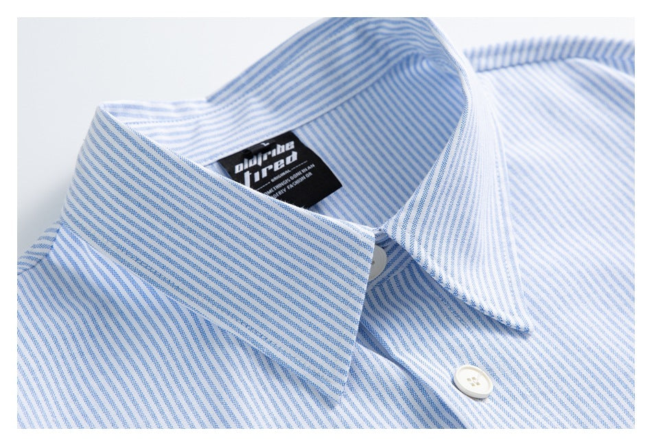 Close-up of a blue-and-white striped shirt collar, white buttons, and a black neck label.