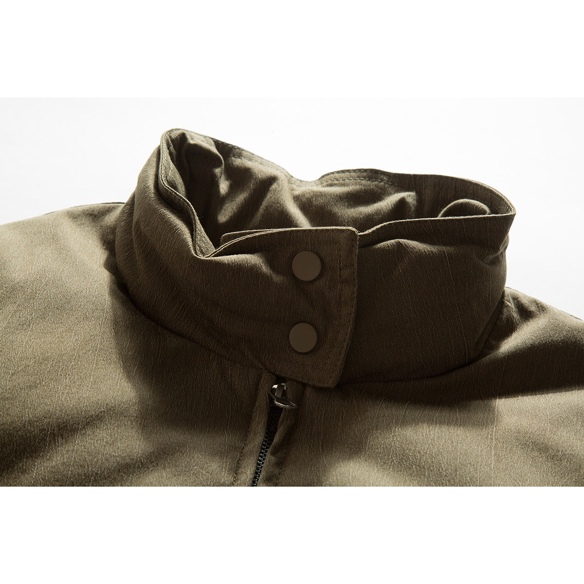 Close-up of an olive-brown jacket collar with two snap buttons and a front zipper.