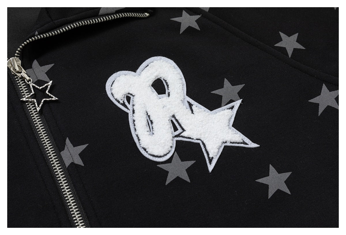Close-up of a black jacket showing gray stars, a silver zipper with star charm and a white fuzzy star patch.