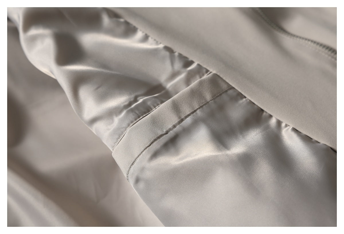 Close-up of taupe trouser fabric and inner seam, with part of a zipper visible.