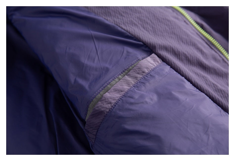 Close-up of the purple jacket's interior lining and stitched seam, with part of the lime-green zipper visible.