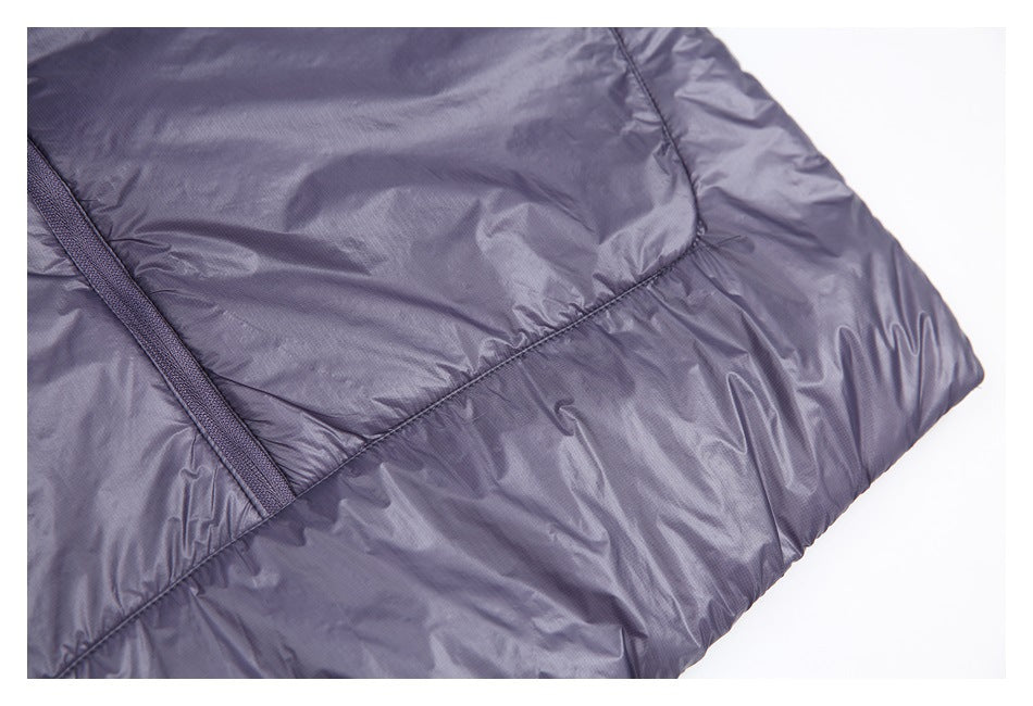 Close-up of a shiny lavender-gray padded garment with curved stitched panels and a narrow bound seam.