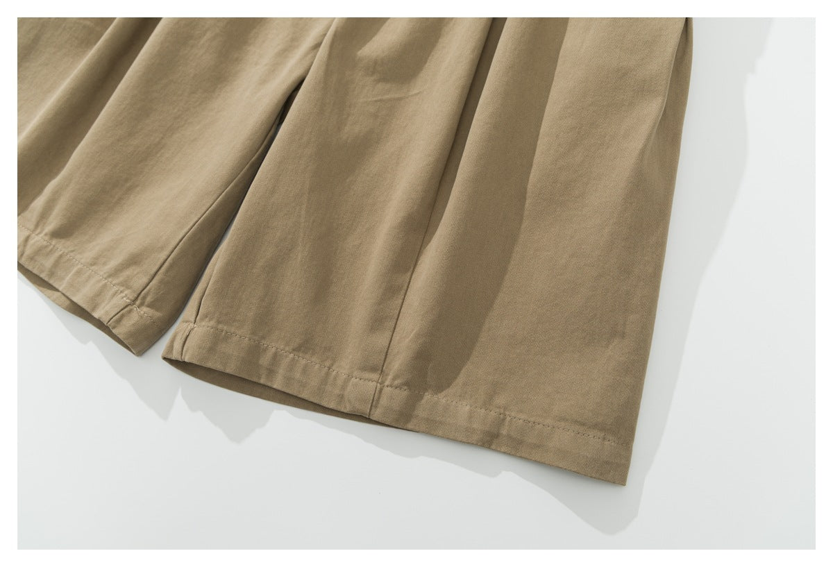 Close-up of the wide khaki pant legs and stitched hems.