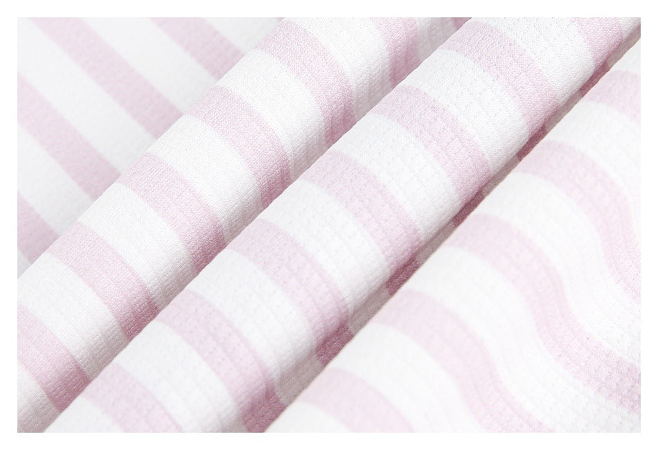 Close-up of soft-looking pink-and-white striped fabric arranged in folds.
