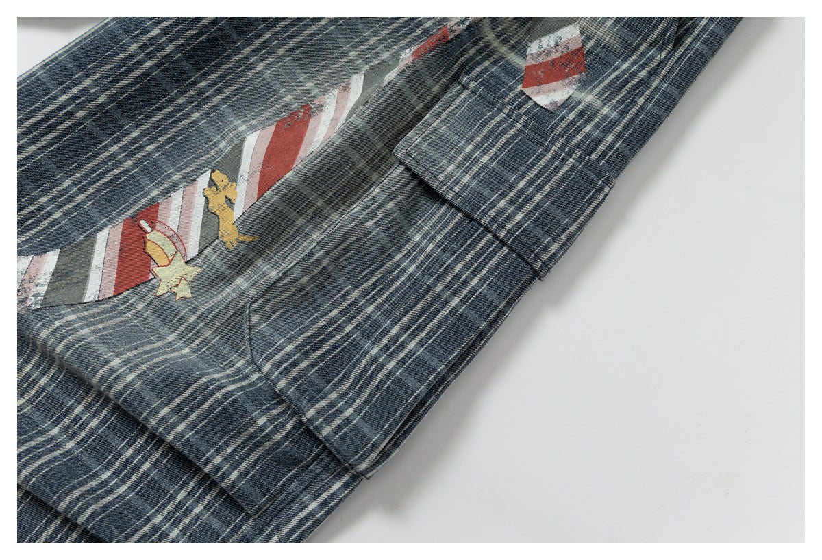 Close-up of plaid trousers with a small colorful star-and-character graphic and a stitched pocket.