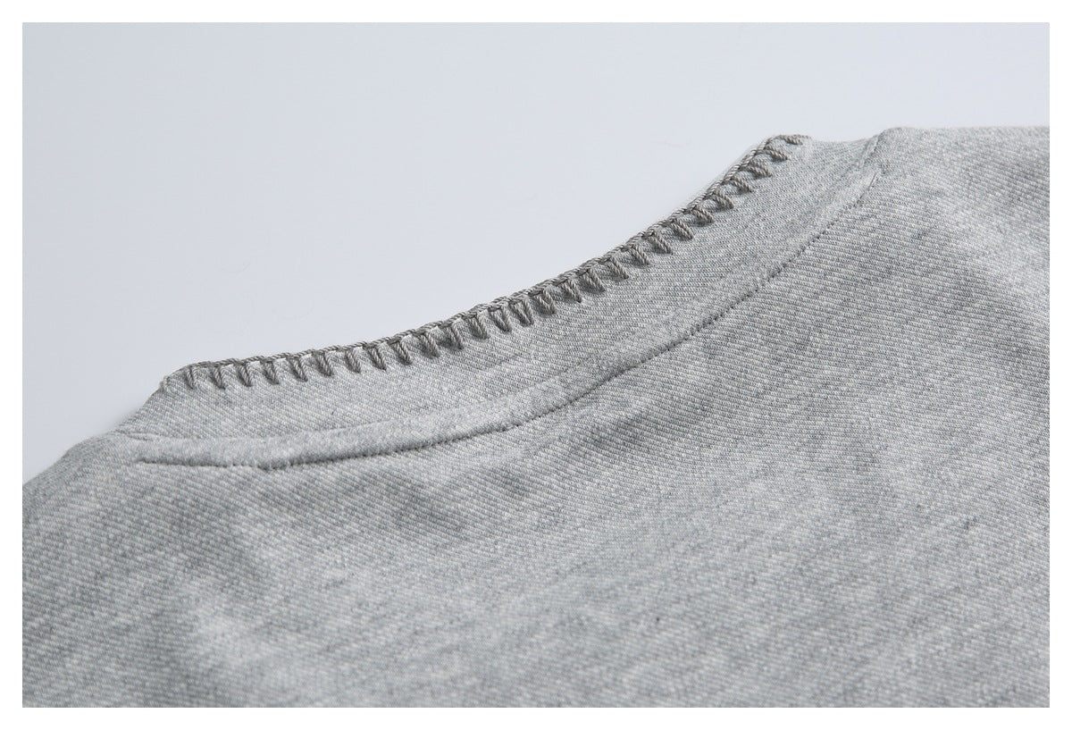 Close-up of a gray garment neckline and stitched collar seam.