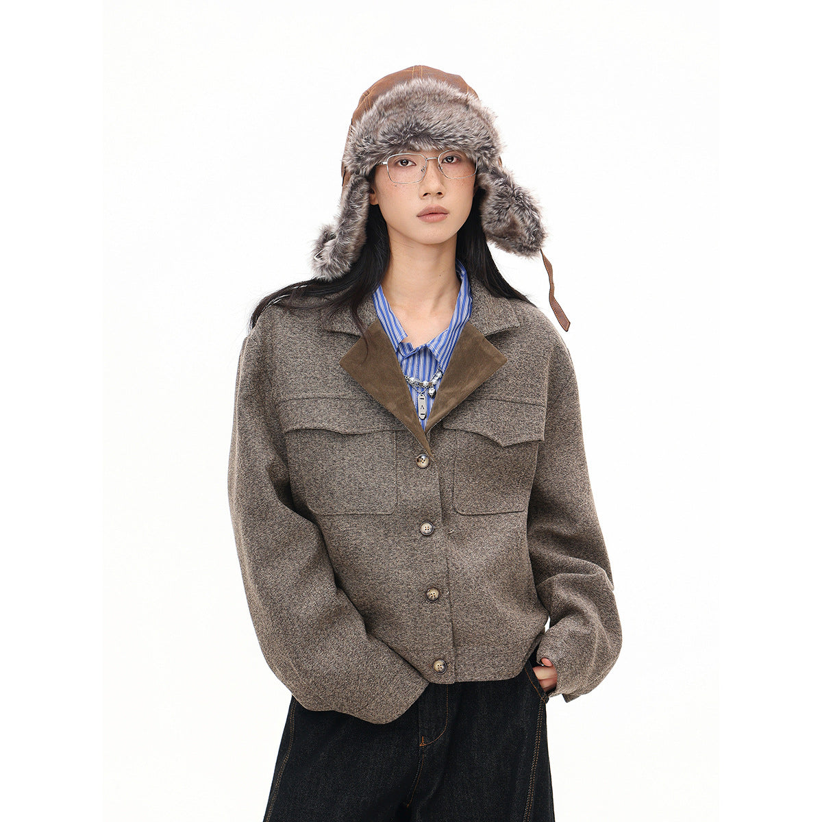 Model wearing a mottled brown button-front jacket with large pockets and suede-look lapels, styled with a fur-trimmed hat.