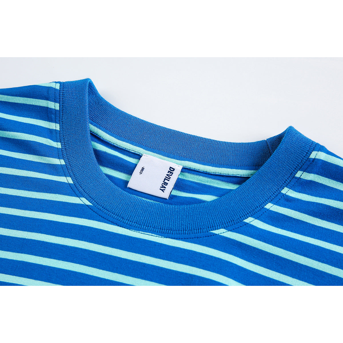 Close-up of a blue and pale aqua striped T-shirt neckline with a ribbed collar and a DEVILRAY label.