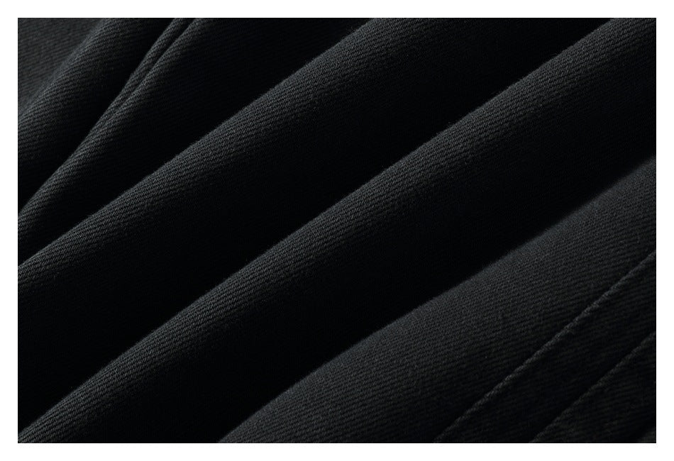 Macro view of the dark woven texture and folds of black pants fabric.
