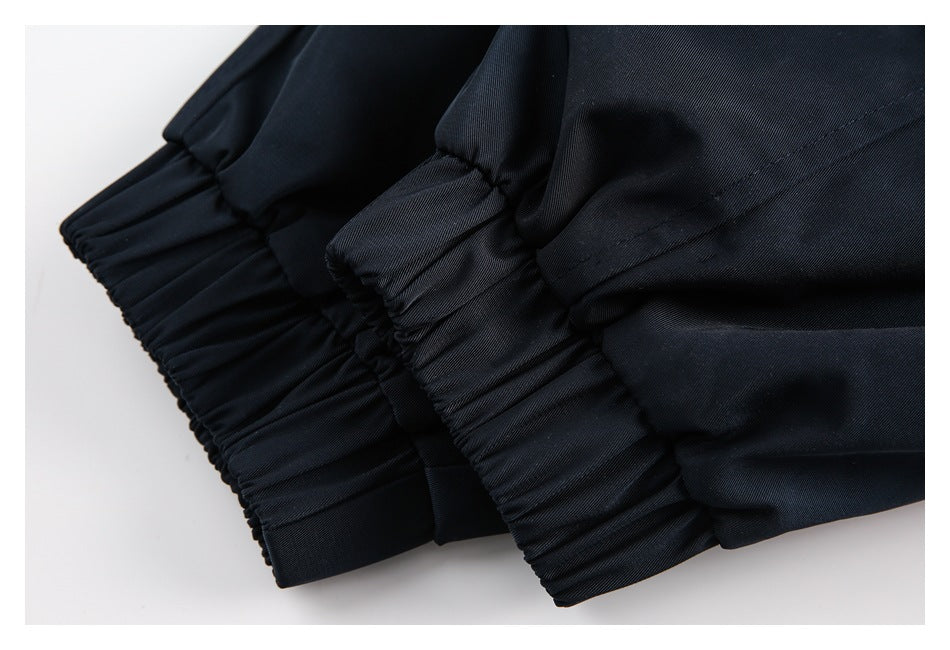 Close-up of two gathered elastic cuffs on a dark navy garment.