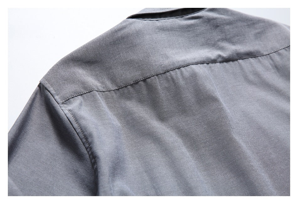 Close-up of the gray shirt's back yoke, collar, and shoulder seam.