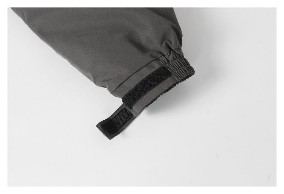 Close-up of a jacket sleeve cuff with elastic gathering and an adjustable hook-and-loop tab.