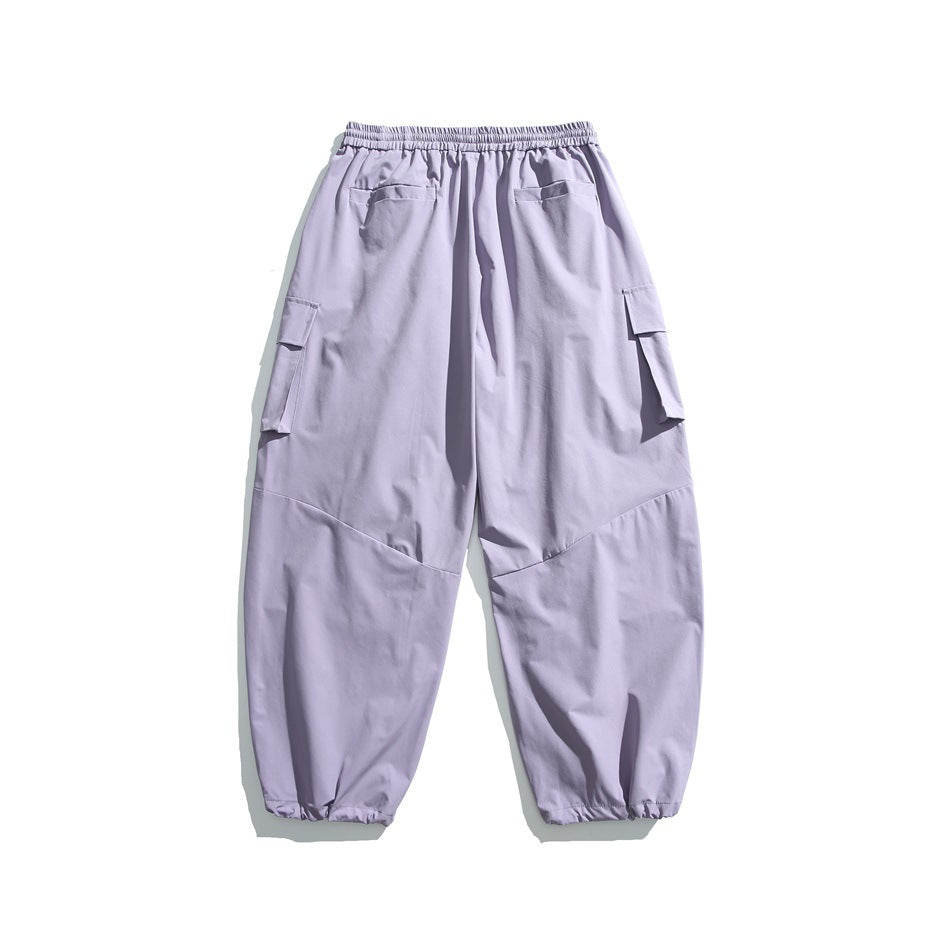 Back view of pale lavender cargo pants with an elastic waistband, rear pockets, flap side pockets, and gathered cuffs.