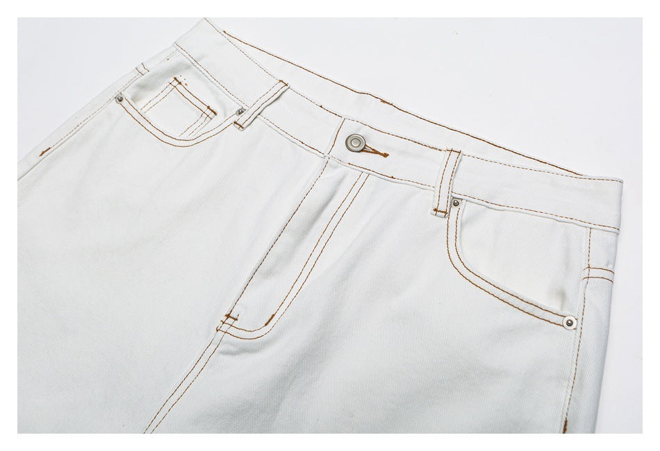 Close-up of the jeans’ front waistband, button, fly, belt loops, and curved front pockets.