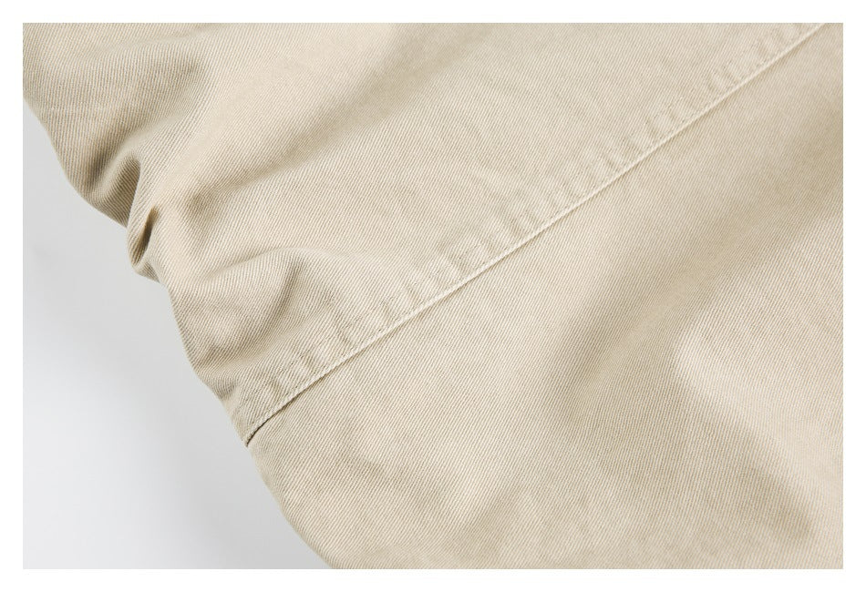 Close-up of a diagonal stitched seam across beige garment fabric.