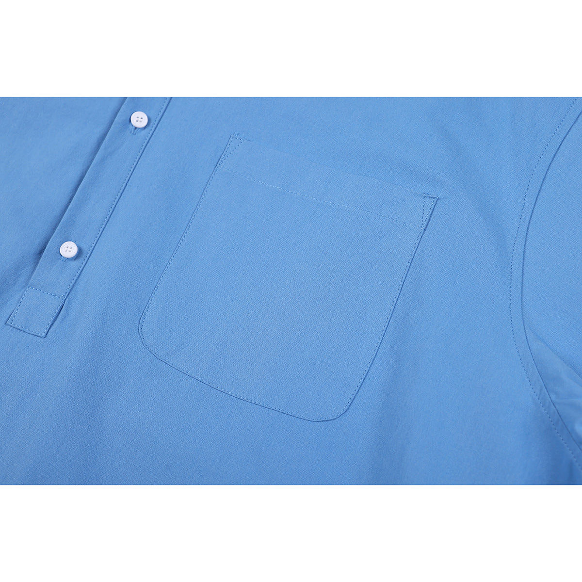 Close-up of a light blue shirt's stitched chest pocket and white buttons.
