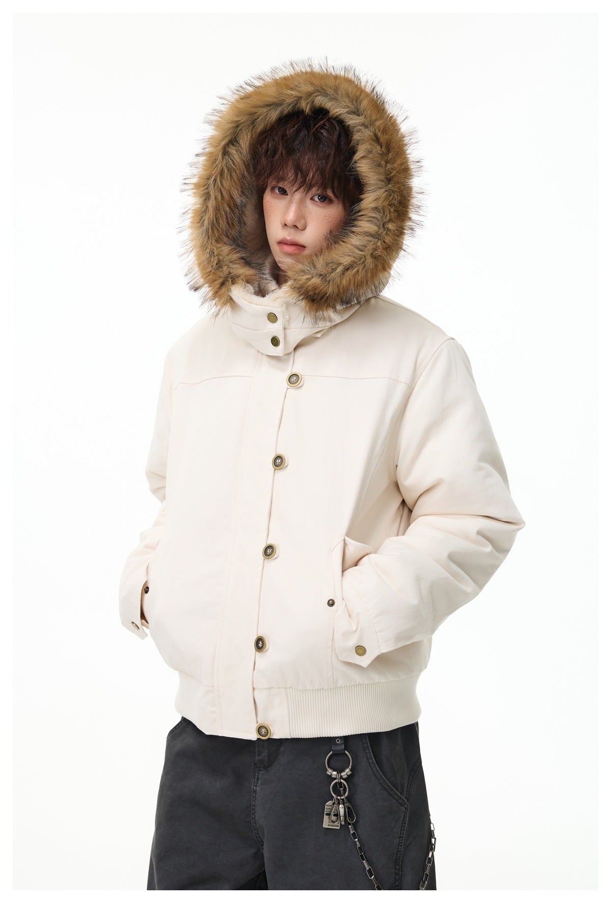 Model wearing a button-front ivory jacket with its fur-trimmed hood up.