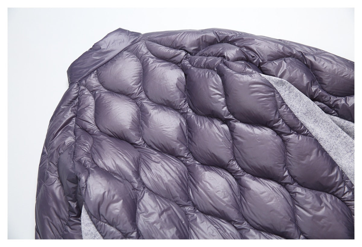 Close-up of the jacket's dark plum-gray quilted lining with curved stitched panels and gray heather exterior.