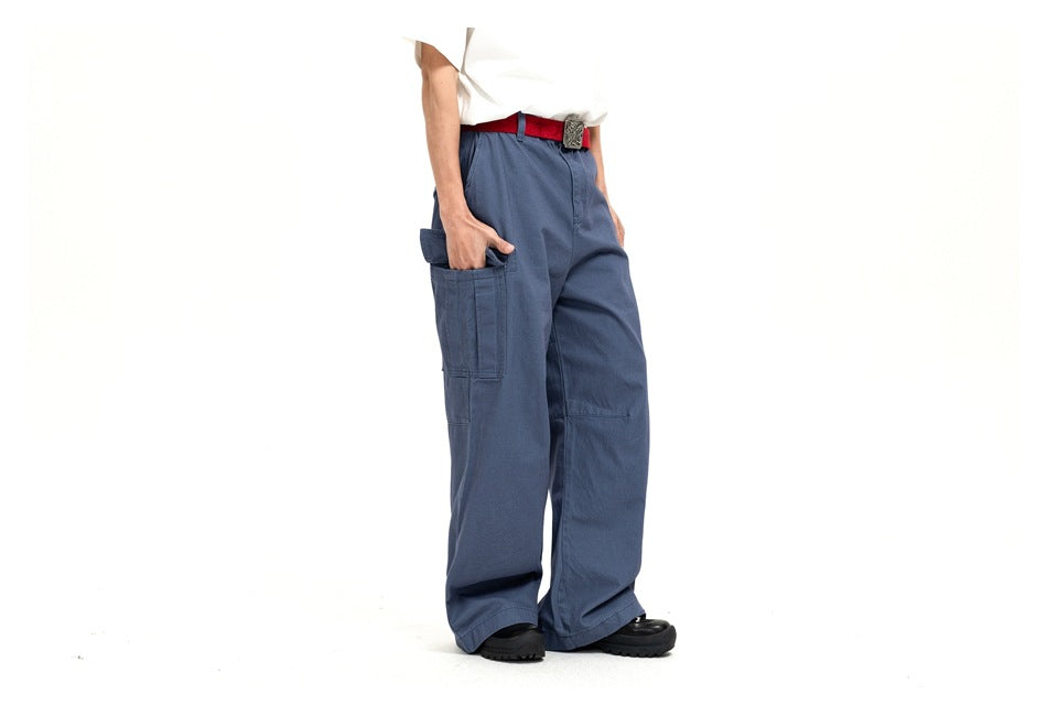 Cropped three-quarter view of a model wearing blue wide-leg cargo pants with a large thigh pocket.