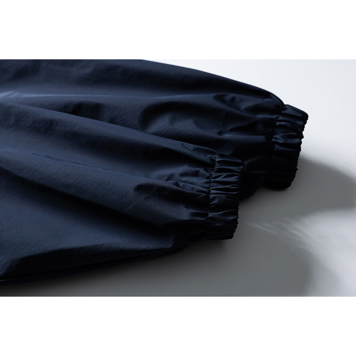 Close-up of the gathered elastic cuffs on a dark navy jacket.