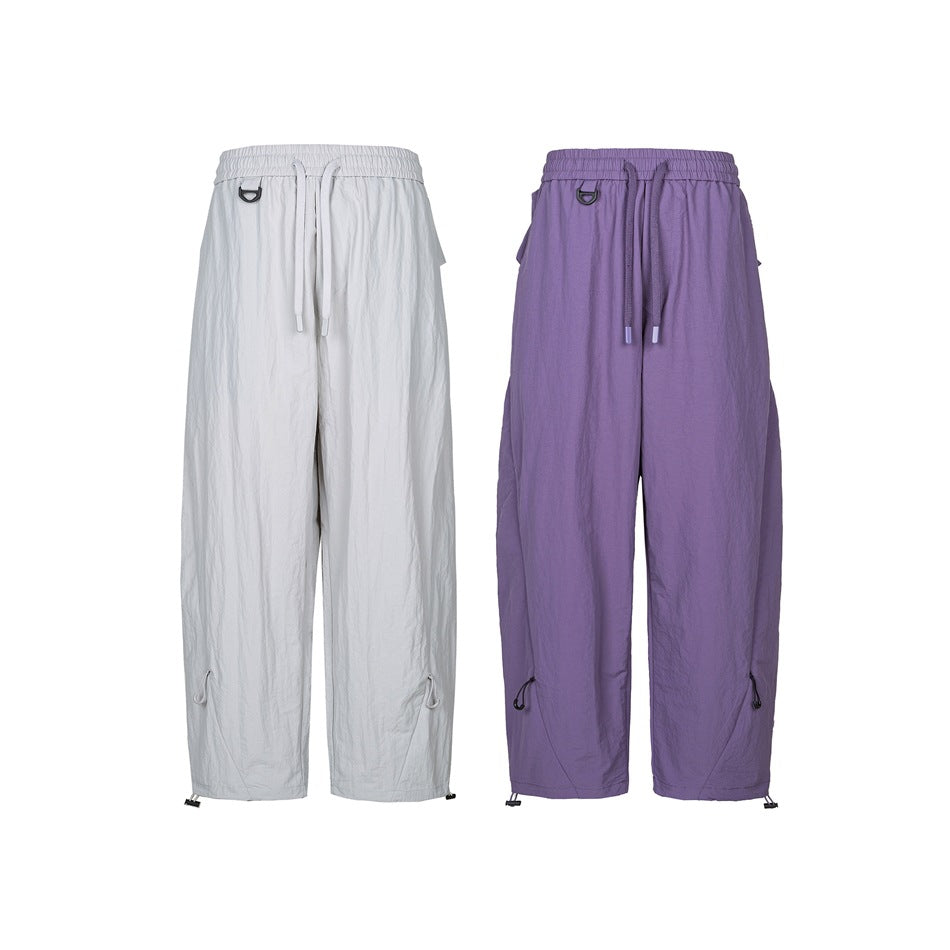Front view of relaxed-fit pants in white and purple, with elastic drawstring waists and adjustable hems.
