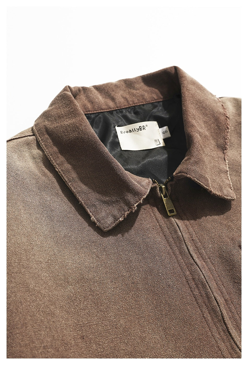 Close-up of a brown jacket collar, gold-tone zipper, and sewn-in neck label.