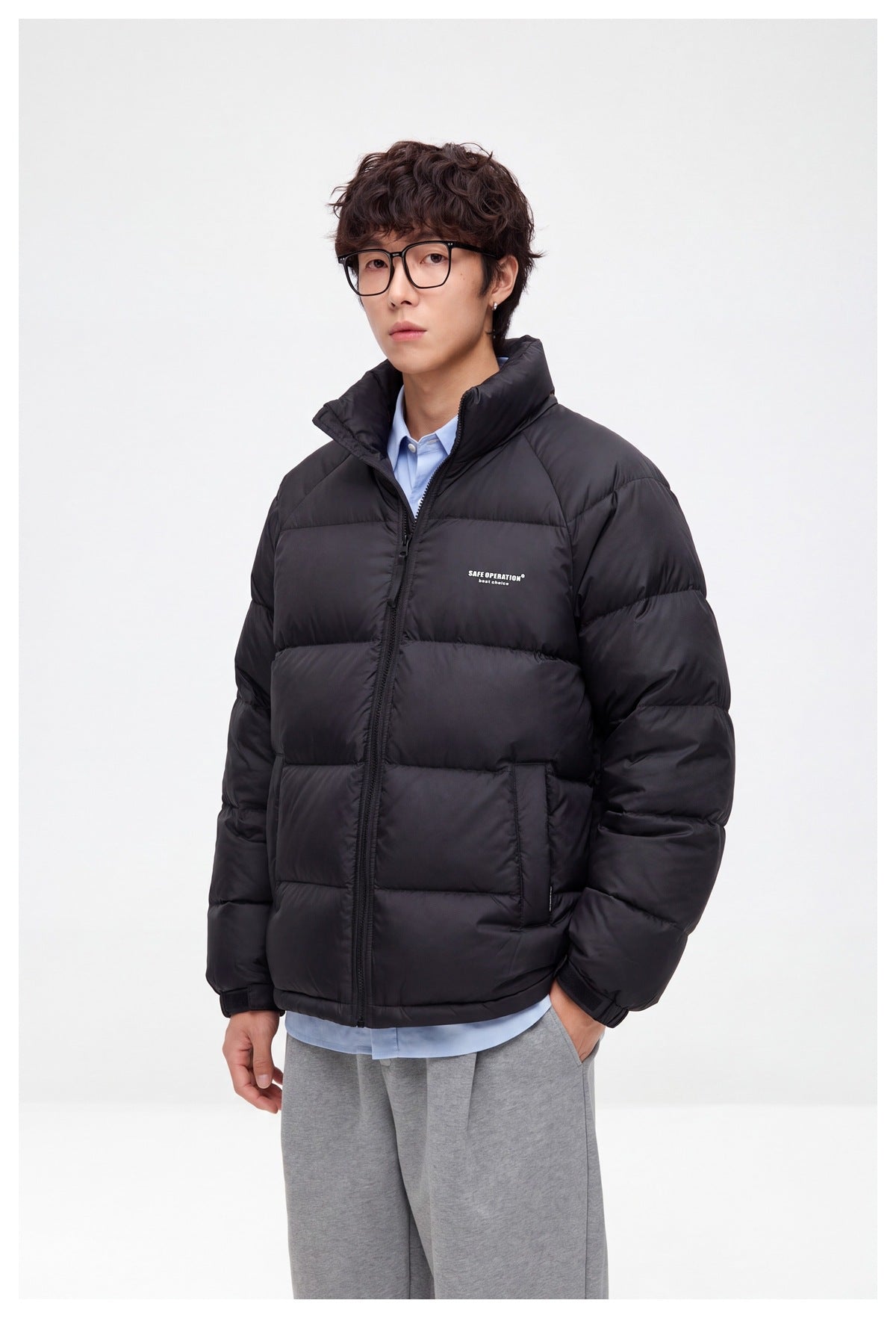 Model wearing a black quilted puffer jacket with a raised collar and front zipper, shown at a three-quarter angle.