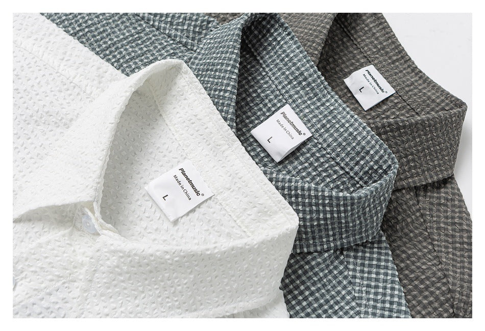 Three collared shirts in white, gray check, and dark gray check, shown folded with their size labels visible.