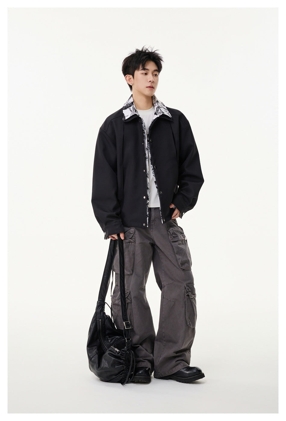 Full-length model wearing a black jacket with a black-and-white floral-print collar and gray cargo trousers.
