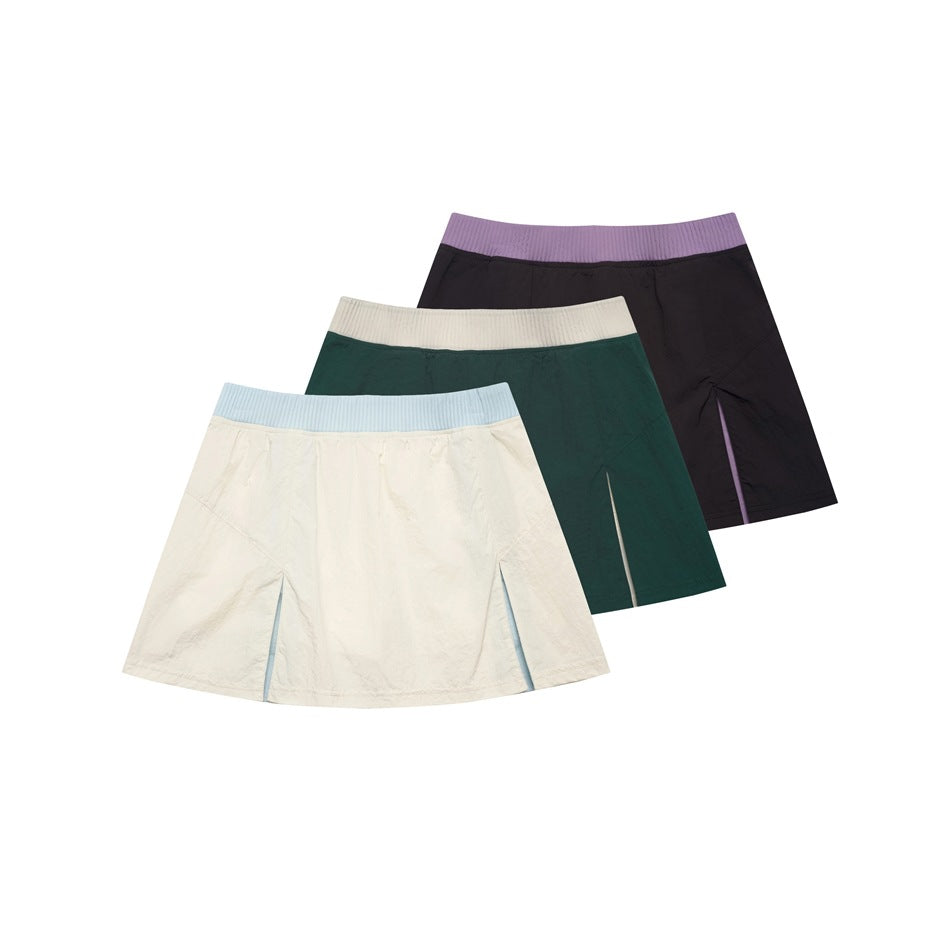 Three flared skirts shown together: ivory with a blue waistband, dark green with an ivory waistband, and black with a
