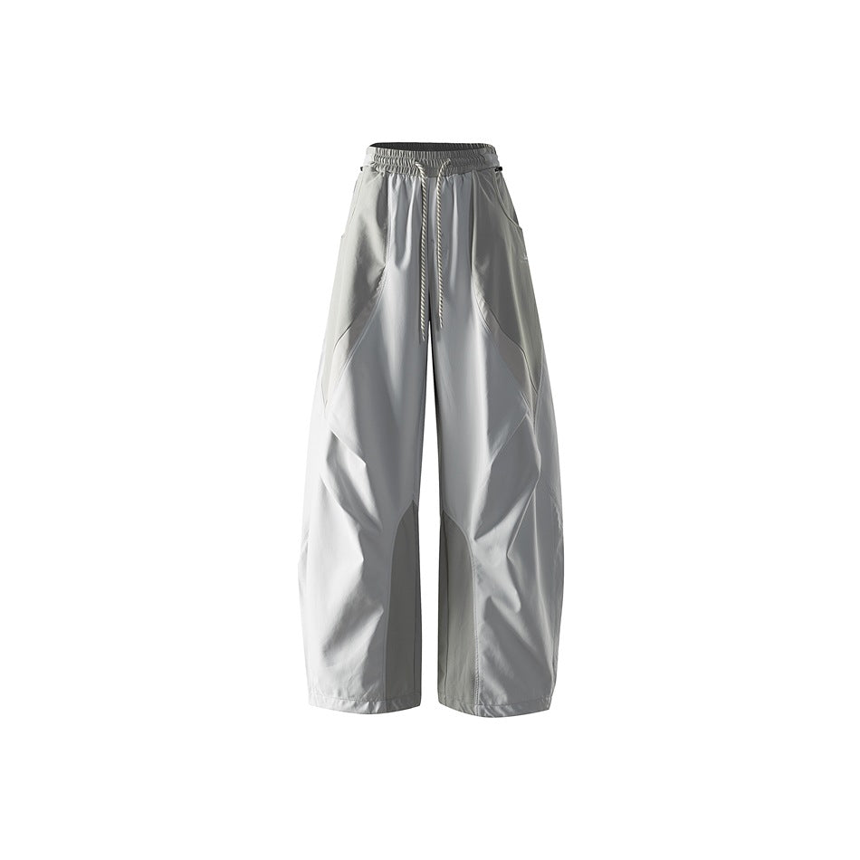 Light gray wide-leg drawstring pants with curved color-blocked panels, shown flat from the front