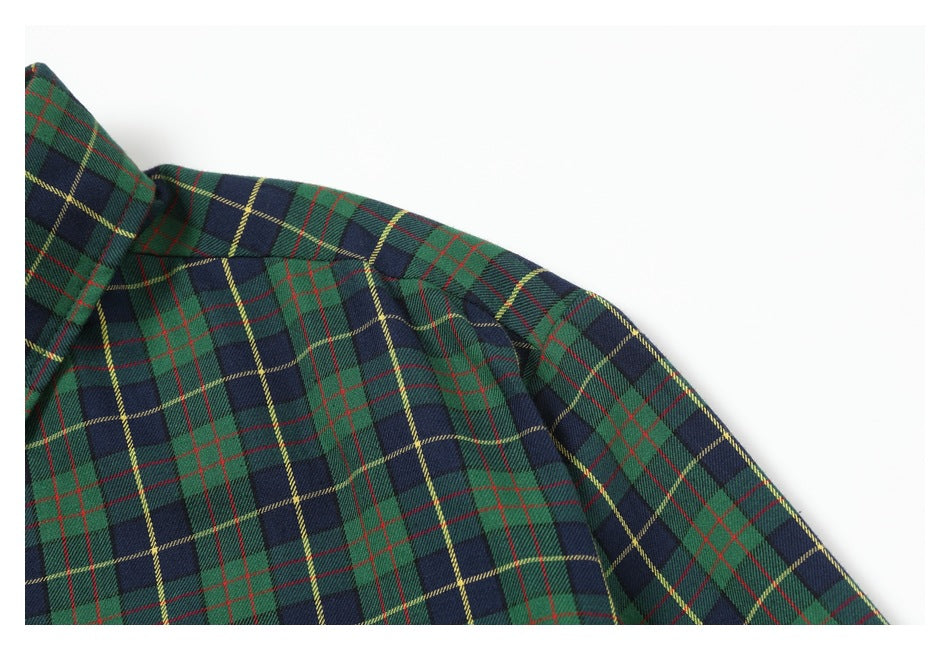 Close-up of a green and navy tartan shirt shoulder and collar with red and yellow lines.