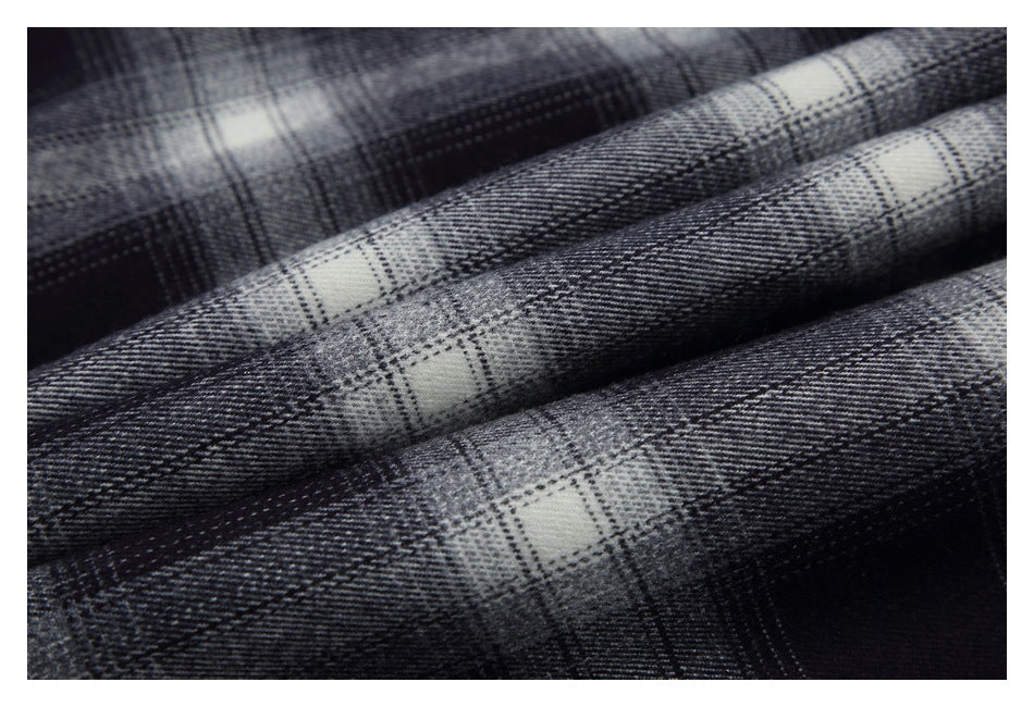 Close-up of the black, gray, and white plaid fabric folded into soft ridges.