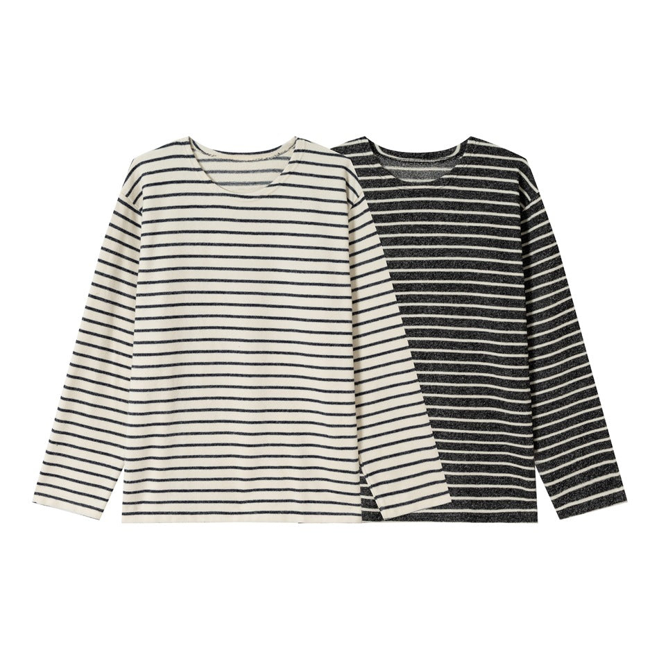 Two overlapping long-sleeve striped shirts: one cream with dark stripes and one dark with cream stripes.