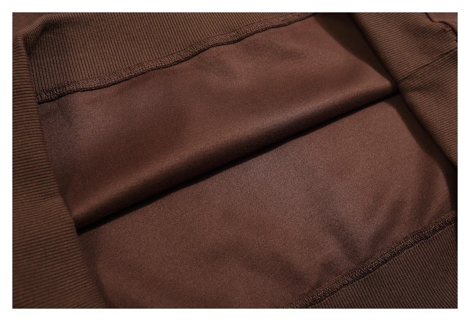 Close-up of brown garment fabric with stitched seams and ribbed edges.