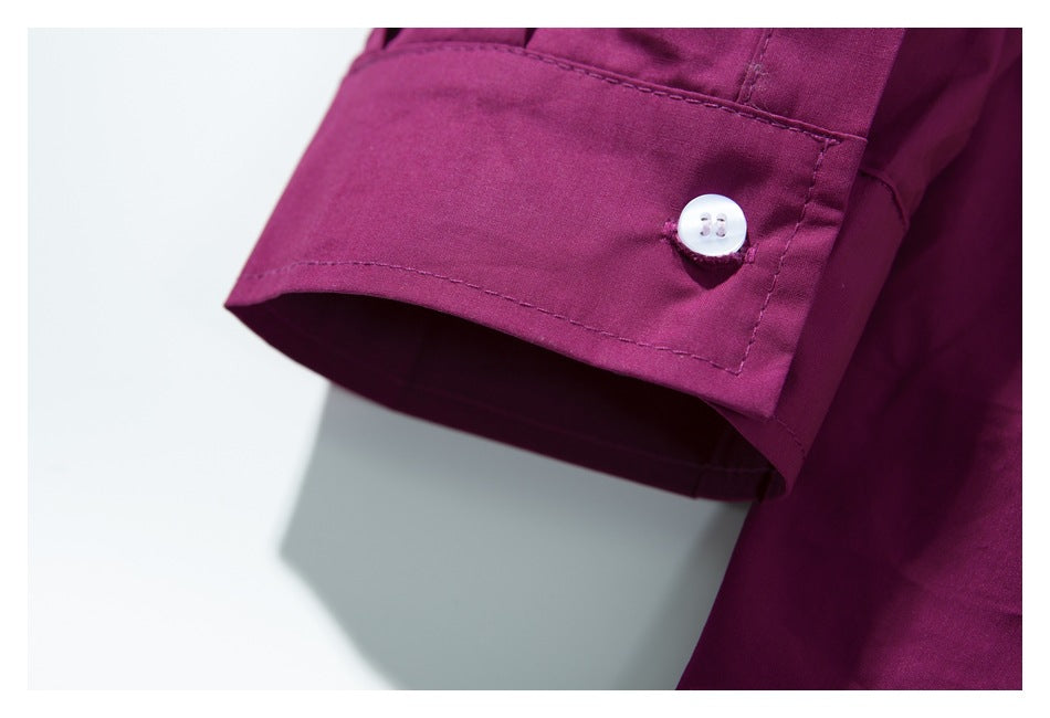 Close-up of a deep magenta sleeve cuff with a small white button and visible stitching.