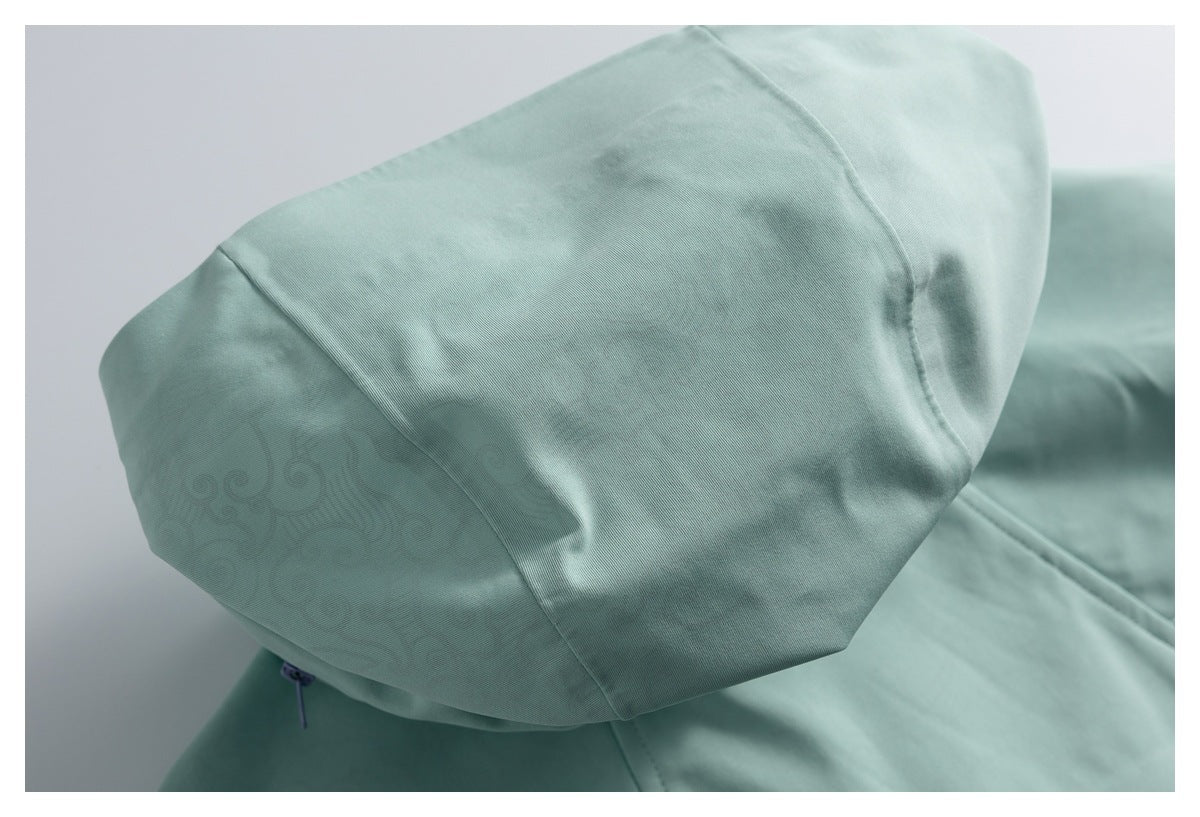 Close-up of a mint garment hood with panel seams and a subtle tonal swirl pattern.