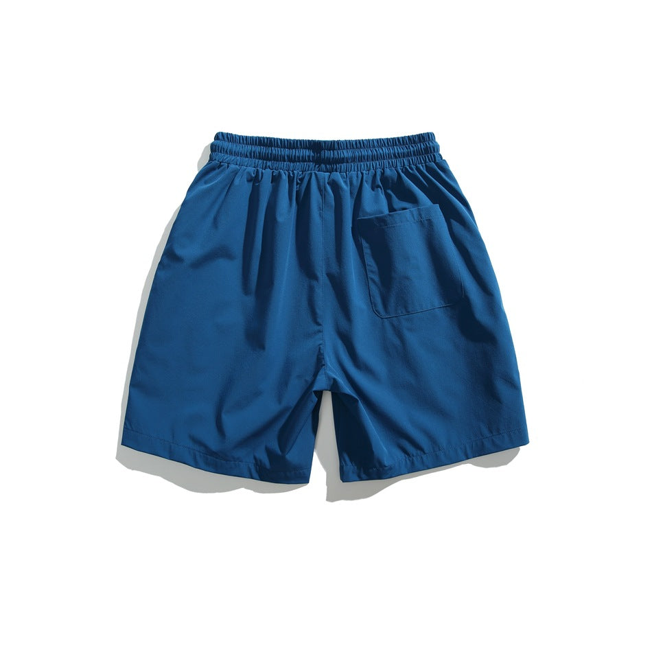 Blue athletic shorts shown from the back, with an elastic waistband and a single rear pocket.