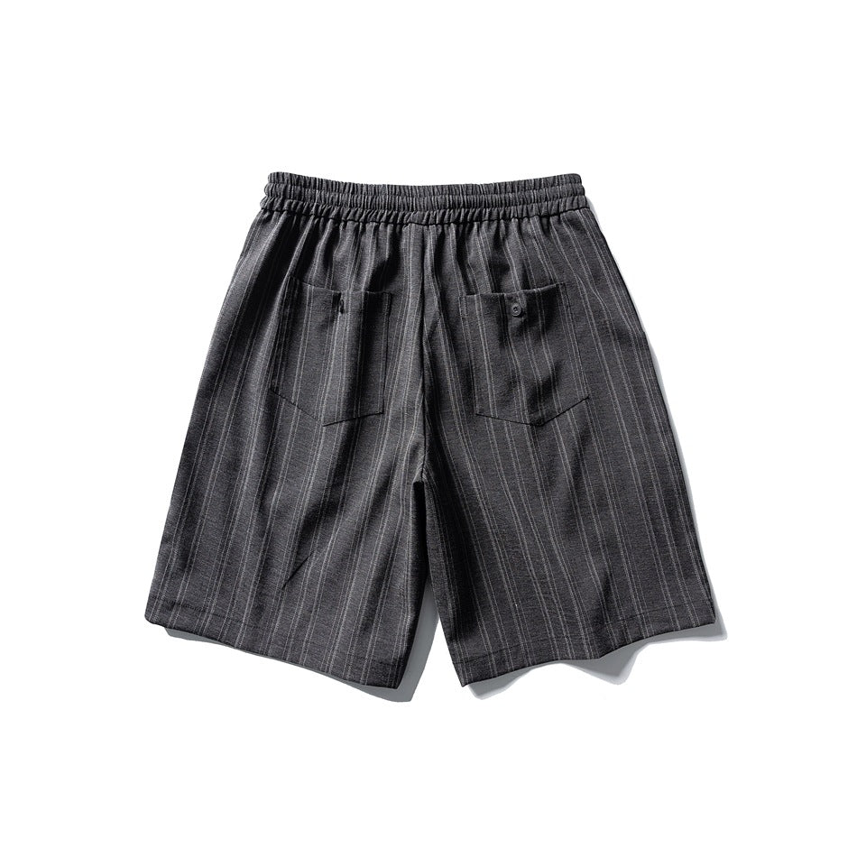 Back view of black pinstriped shorts with elastic waistband and two patch pockets, one with a button