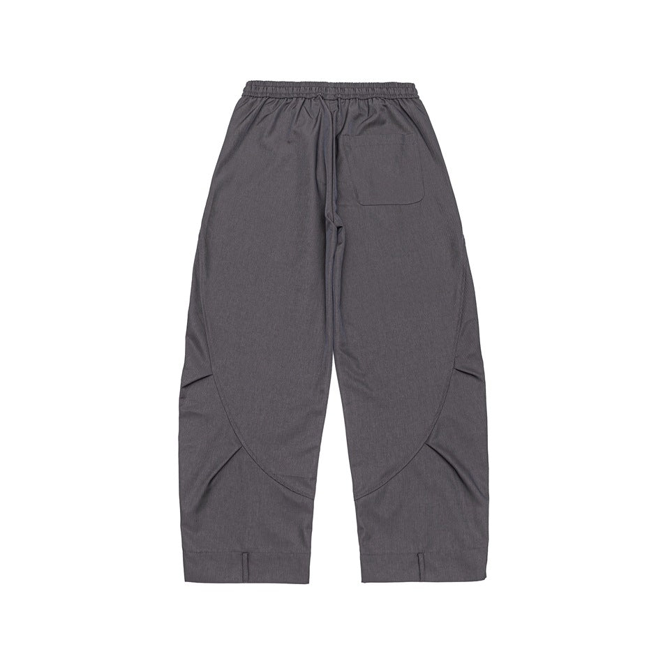Back view of gray drawstring pants laid flat, showing a rear pocket and curved leg seams.