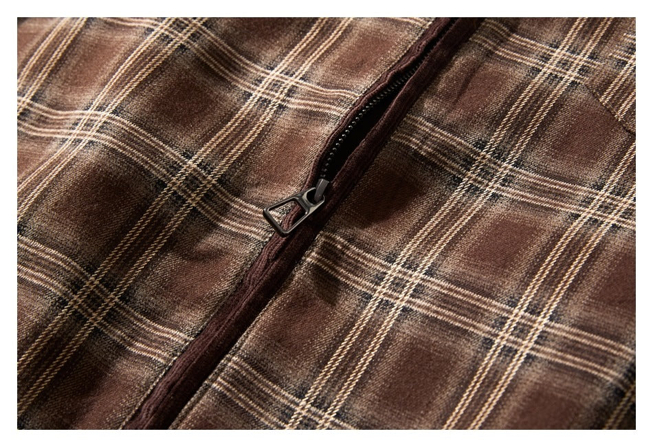 Close-up of a dark zipper on brown plaid fabric.